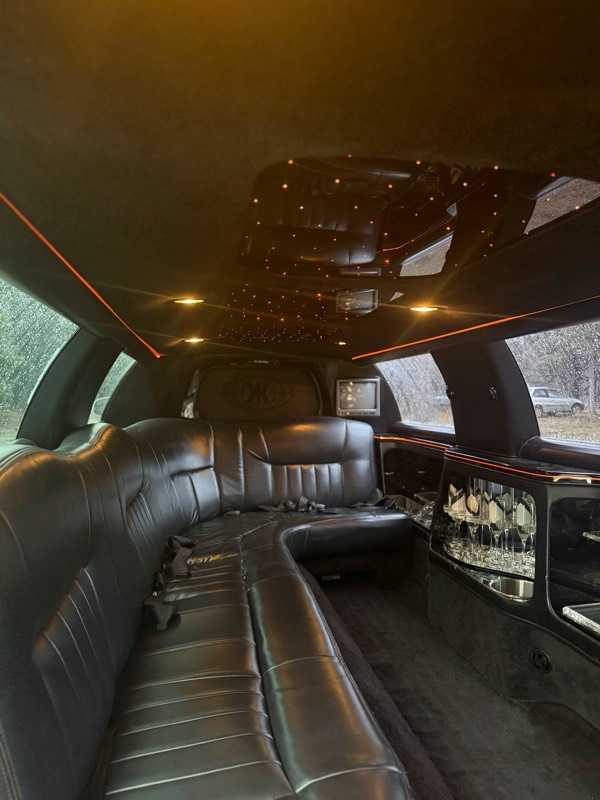 Inside the Lockwood Luxury limousine — leather bench seating, a fiber-optic star headliner, and amber accent lighting